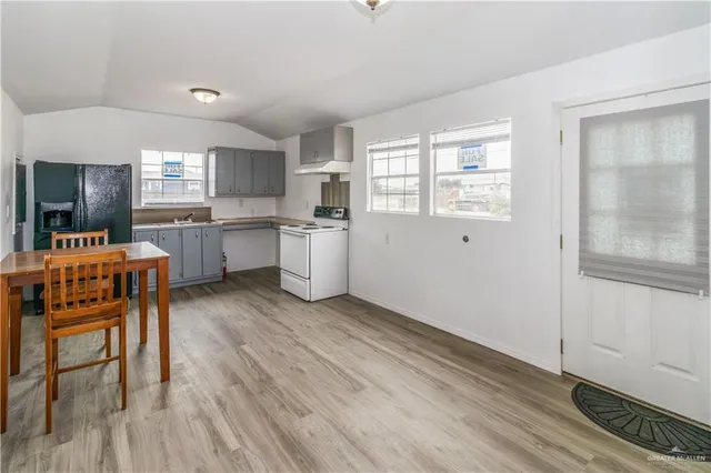 a kitchen with granite countertop a sink appliances cabinets and wooden floor