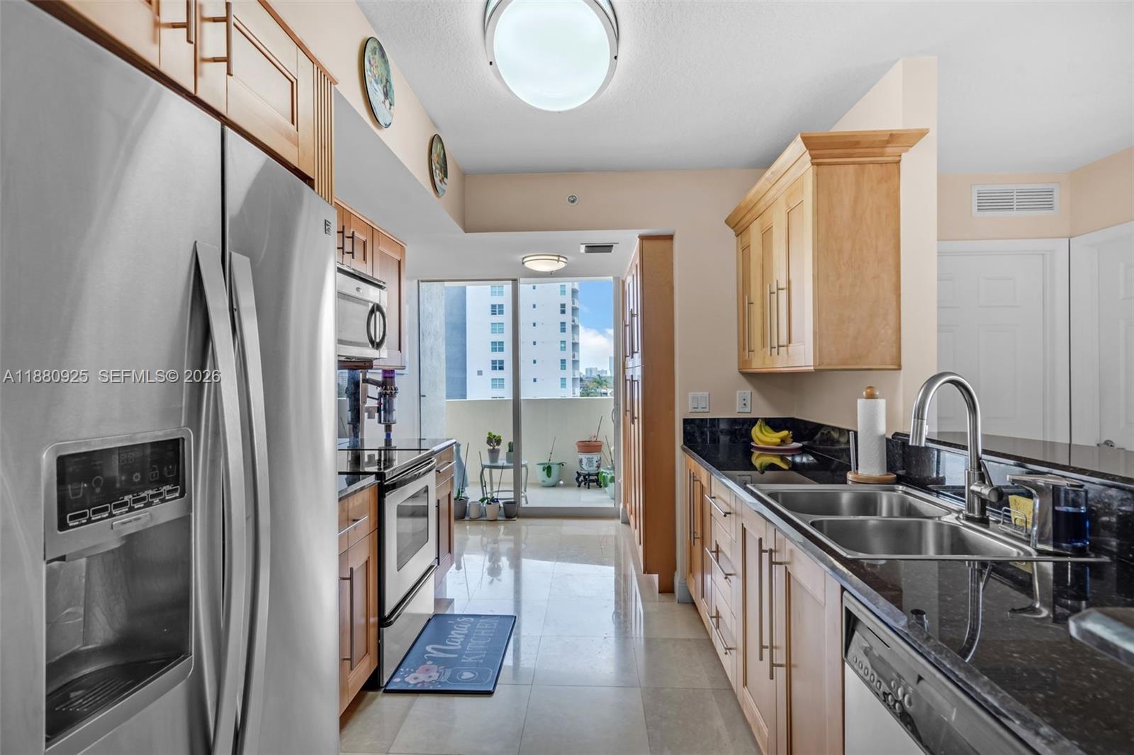 3232 Southwest 22nd Terrace, Unit 801 Miami, FL 33145 - Photo 3 of 23 a kitchen with stainless steel appliances granite countertop a refrigerator a sink dishwasher a stove and a dining table with wooden floor