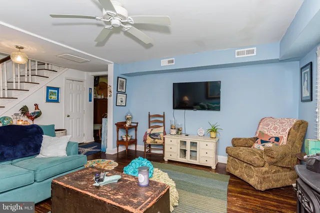 a view of a white house with large windows and a small yard
