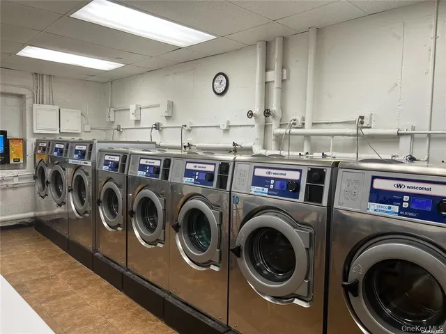 a utility room with dryer washer and a view of kitchen