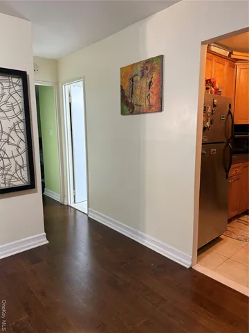 a view of a hallway with wooden floor and closet