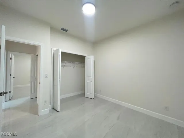 an empty room with closet area and mirror