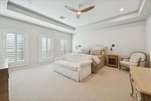 a spacious bedroom with a bed a couch and large window