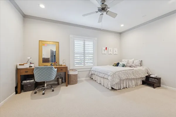 a spacious bedroom with a bed a table and chair