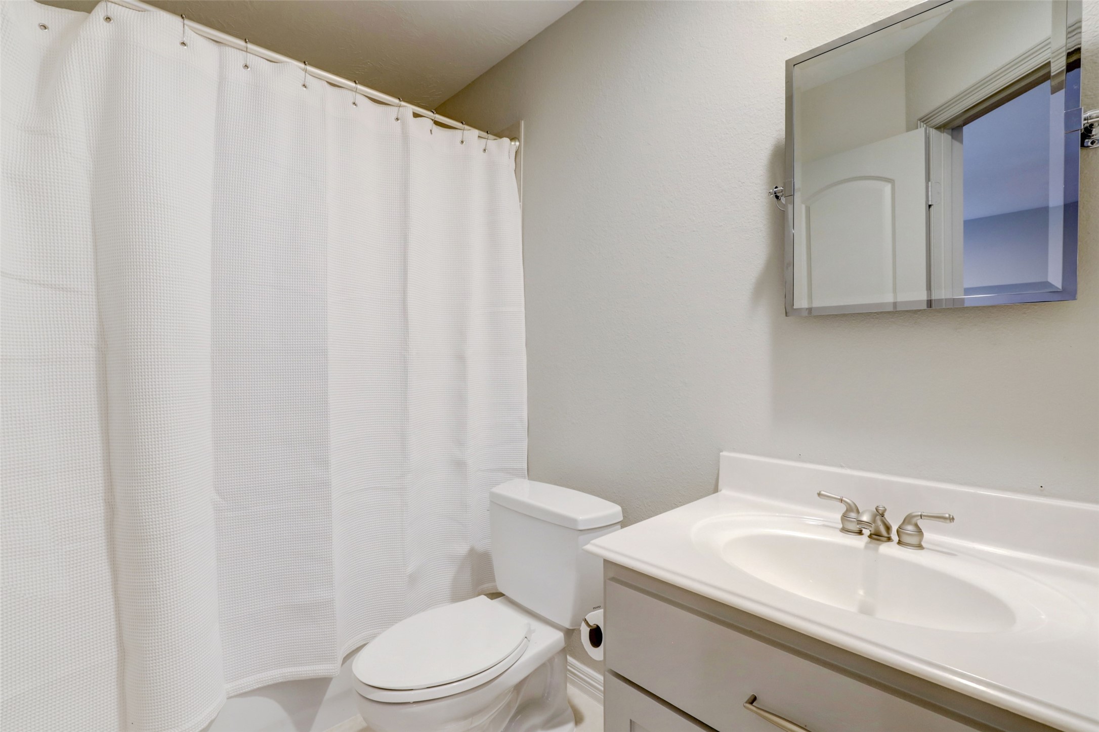 4004 Childress Street Houston, TX 77005 - Photo 29 of 35 a bathroom with a sink a toilet and a mirror