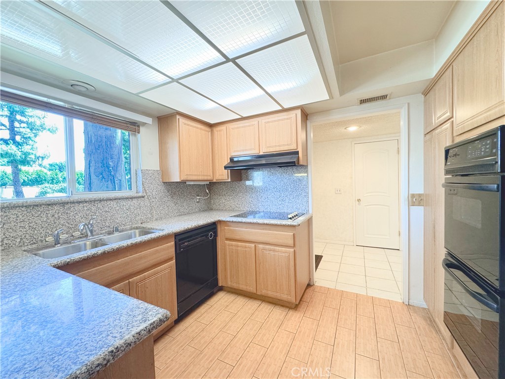 20722 Devonshire Street Chatsworth, CA 91311 - Photo 3 of 20 a kitchen with stainless steel appliances granite countertop a sink stove and refrigerator