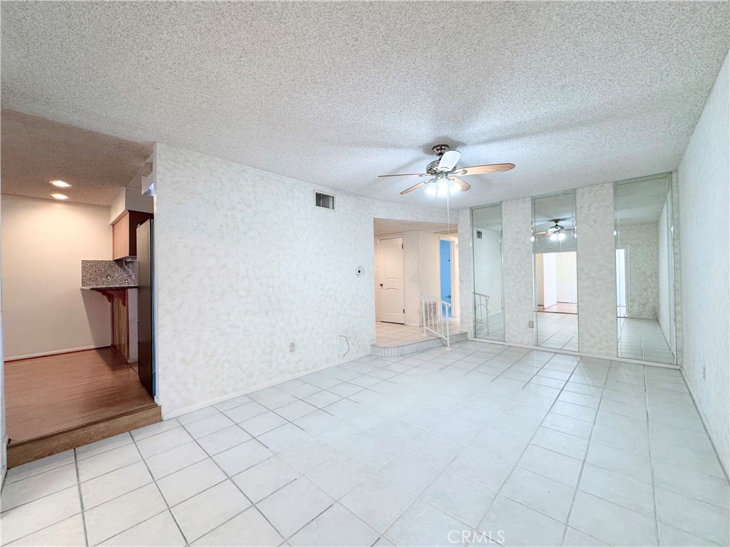 20722 Devonshire Street Chatsworth, CA 91311 - Photo 6 of 20 an empty room with a chandelier fan and windows