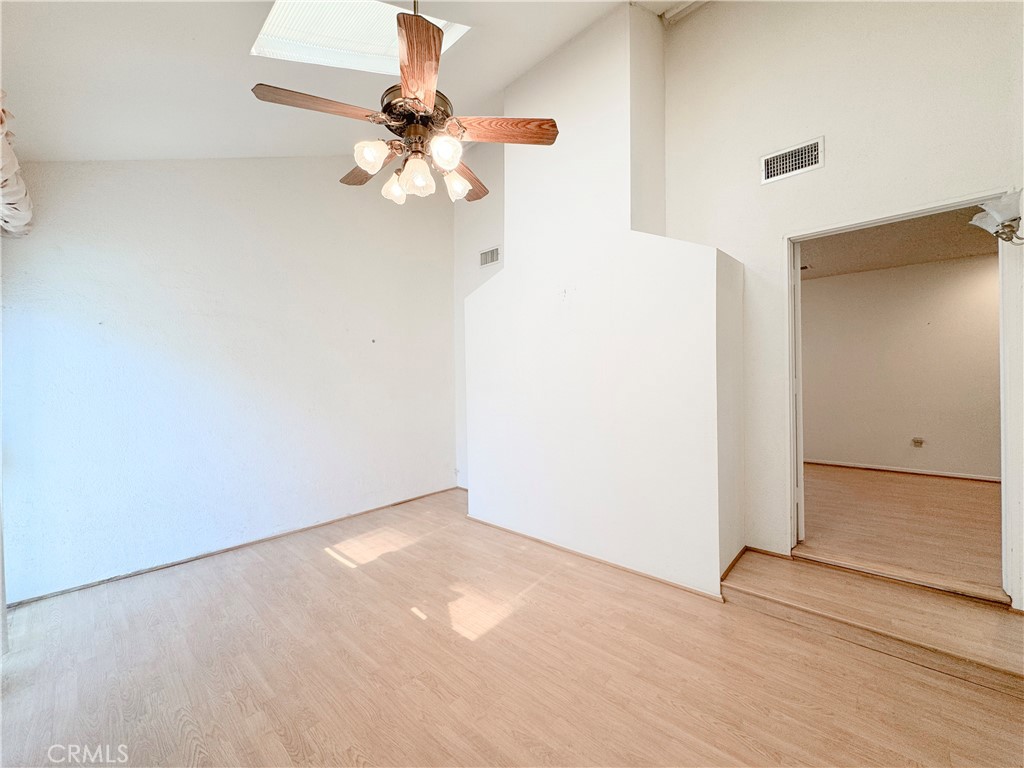 20722 Devonshire Street Chatsworth, CA 91311 - Photo 9 of 20 an empty room with a chandelier fan and wooden floor