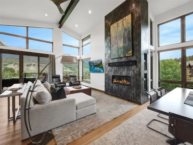 a living room with furniture fireplace and large windows