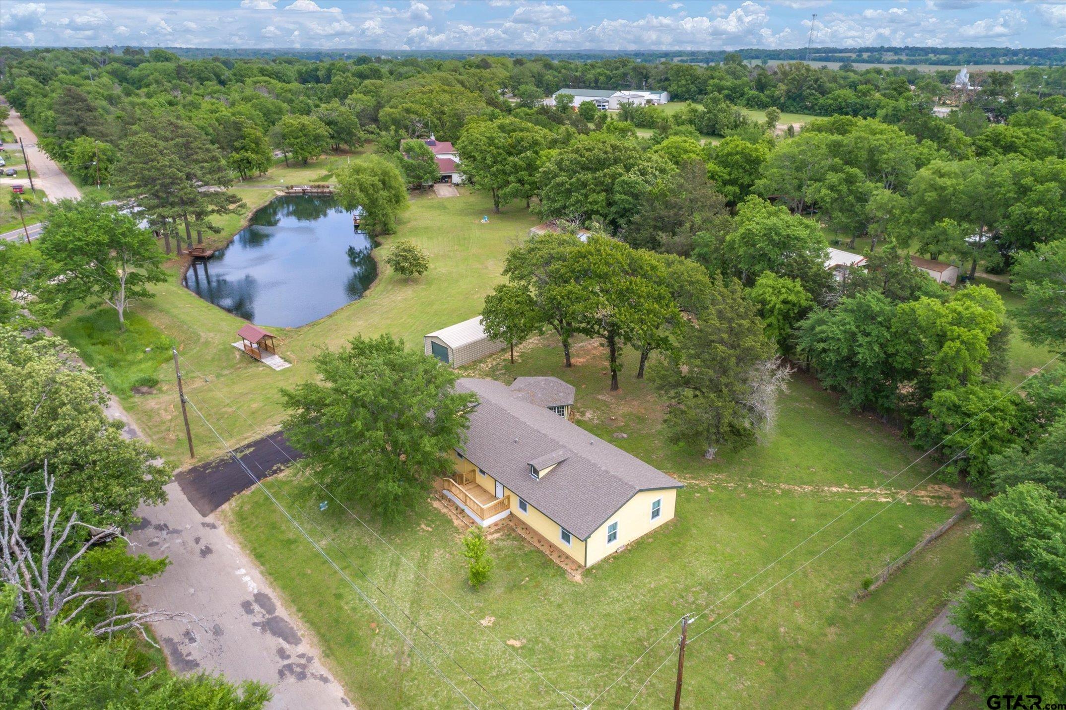 a aerial view of a house with a yard and lake view