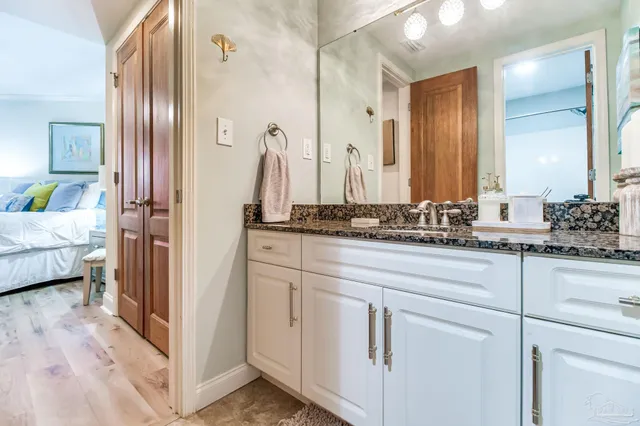 a bathroom with a granite countertop toilet sink and mirror