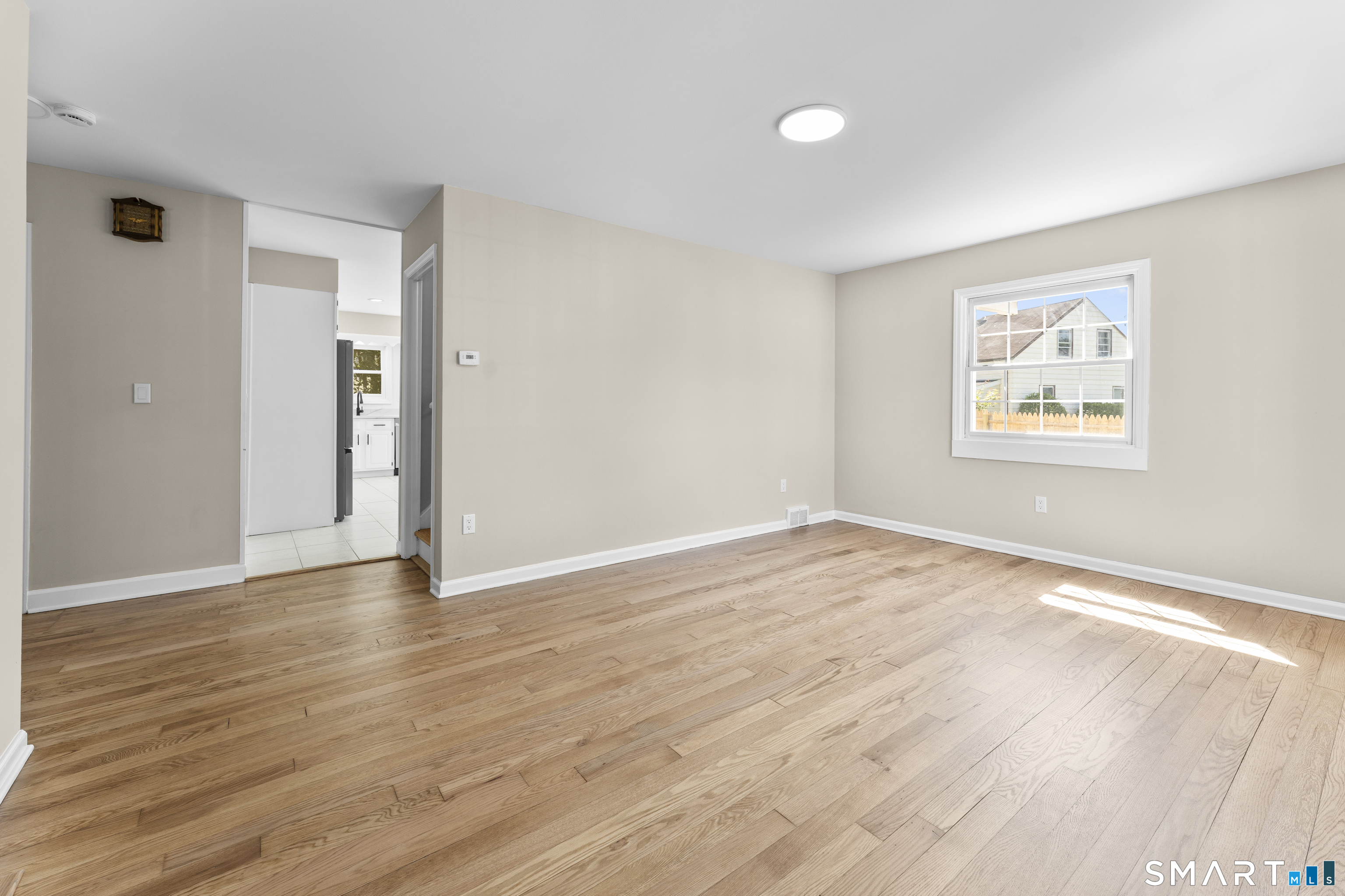 110 Minturn Road Bridgeport, CT 06606 - Photo 3 of 29 a view of an empty room with wooden floor and a window