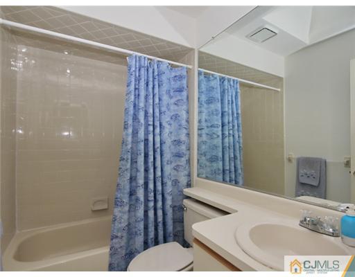 4504 Stonehedge Road Edison, NJ 08820 - Photo 12 of 16 a bathroom with a granite countertop sink a toilet and shower