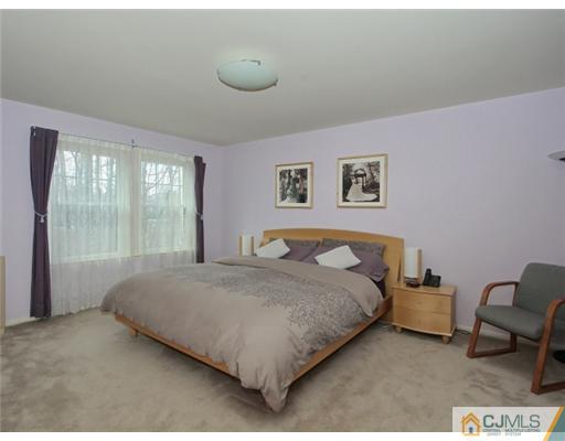 4504 Stonehedge Road Edison, NJ 08820 - Photo 8 of 16 a bedroom with a bed and glass window