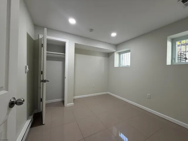 an empty room with windows and closet