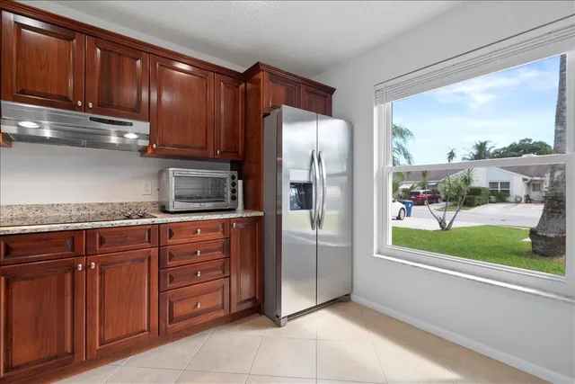 a kitchen with stainless steel appliances granite countertop a refrigerator and a sink