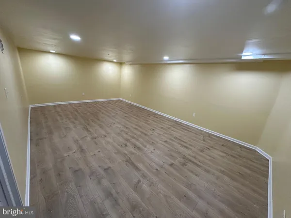 an empty room with wooden floor and windows in it
