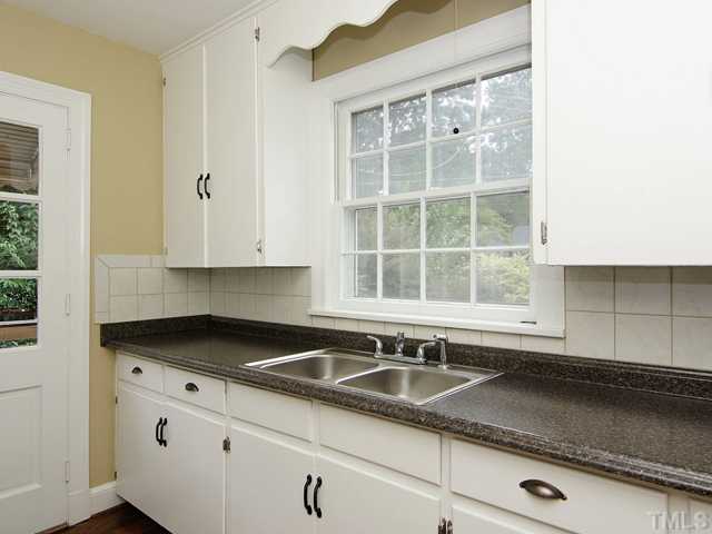 3014 Mayview Road Raleigh, NC 27607 - Photo 8 of 21 a kitchen with granite countertop a sink and a white cabinets