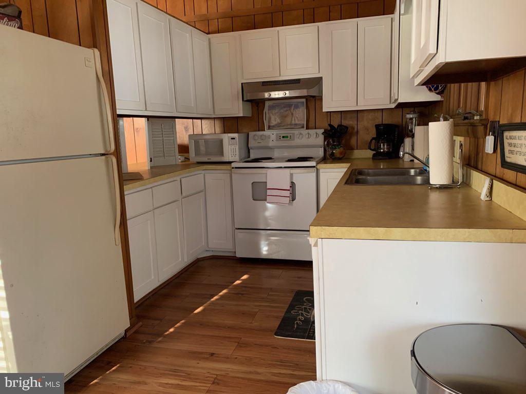 607 Collins Street Bethany Beach, DE 19930 - Photo 7 of 13 a kitchen with a refrigerator a stove a sink and cabinets