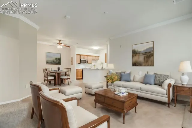 a living room with furniture a rug and kitchen view