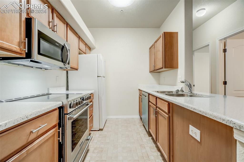 5353 Palomino Ranch Point, Unit 202 Colorado Springs, CO 80922 - Photo 16 of 34 a kitchen with stainless steel appliances a stove microwave and sink