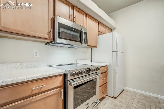 a kitchen with stainless steel appliances white cabinets and a stove top oven