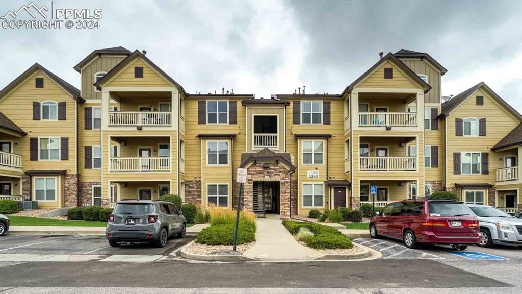 5353 Palomino Ranch Point, Unit 202 Colorado Springs, CO 80922 - Photo 2 of 34 a front view of a residential apartment building with a yard