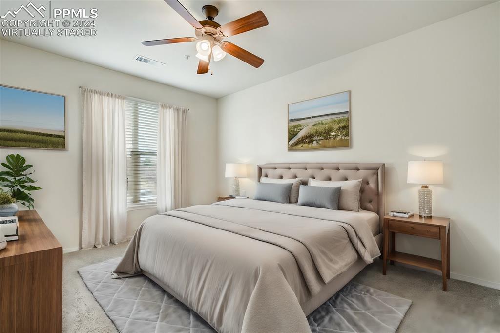 5353 Palomino Ranch Point, Unit 202 Colorado Springs, CO 80922 - Photo 21 of 34 a bedroom with a large bed and a chandelier