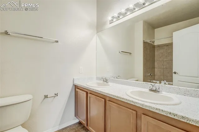 a bathroom with a granite countertop sink a toilet and a mirror