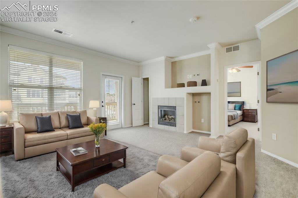 5353 Palomino Ranch Point, Unit 202 Colorado Springs, CO 80922 - Photo 6 of 34 a living room with furniture a fireplace and a large window