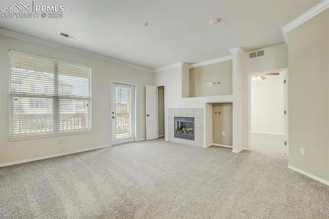 an empty room with fireplace and windows