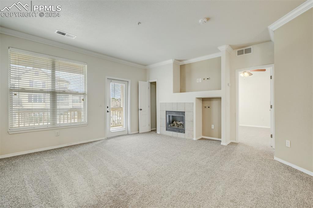 5353 Palomino Ranch Point, Unit 202 Colorado Springs, CO 80922 - Photo 7 of 34 an empty room with fireplace and windows