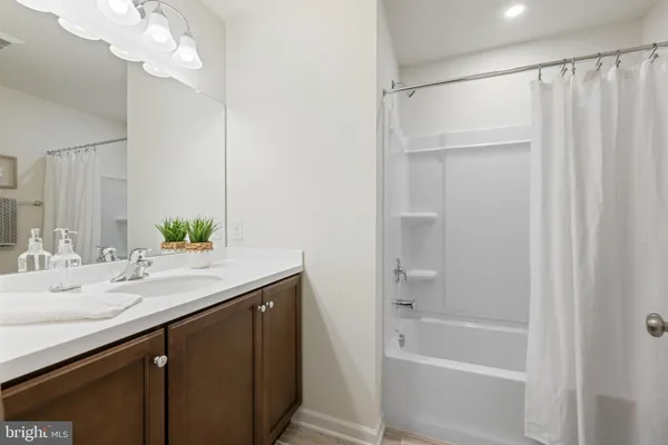 a bathroom with a granite countertop sink a mirror and a bathtub