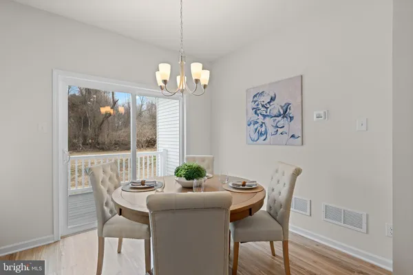 a kitchen with granite countertop a stove a sink a dining table and chairs