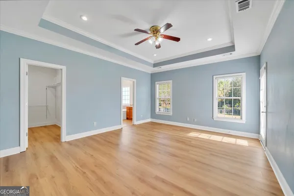 a view of an empty room with window and wooden floor