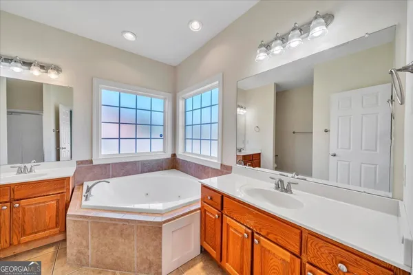 a bathroom with a tub sink and mirror