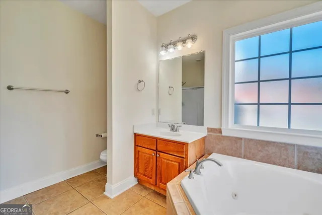 a bathroom with a tub sink and mirror