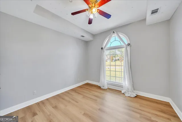 wooden floor in an empty room with a window