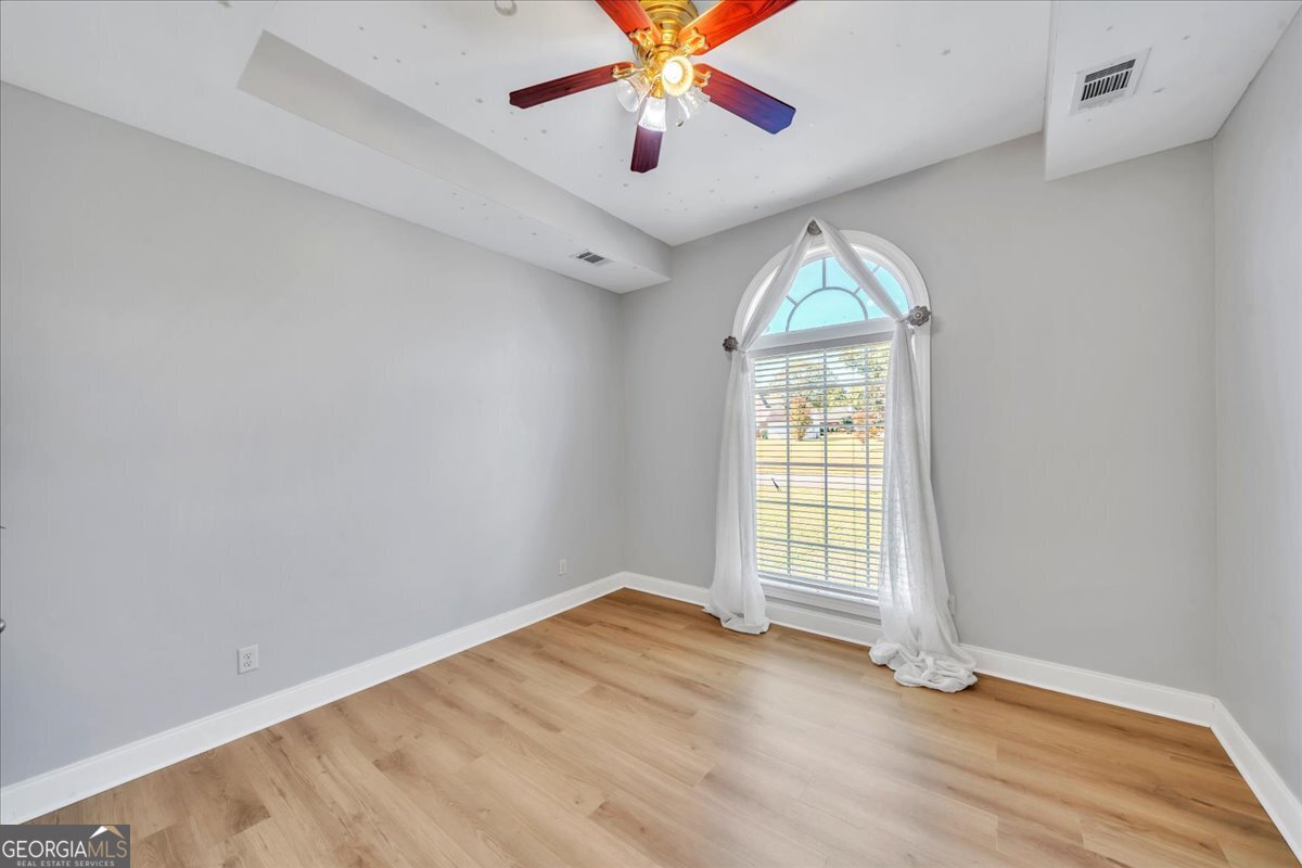 100 Fox Den Court Dublin, GA 31021 - Photo 16 of 26 wooden floor in an empty room with a window