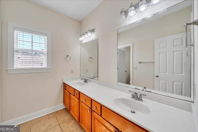 a large bathroom with double vanity sinks a vanity a lamp and a mirror