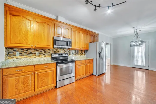 a kitchen with stainless steel appliances granite countertop a stove a sink dishwasher and a refrigerator