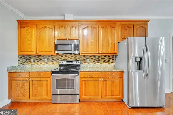 a kitchen with stainless steel appliances granite countertop a refrigerator and a stove top oven
