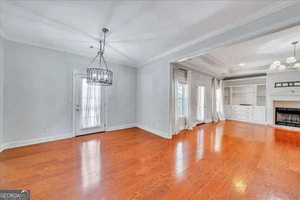 a view of an empty room with window and wooden floor