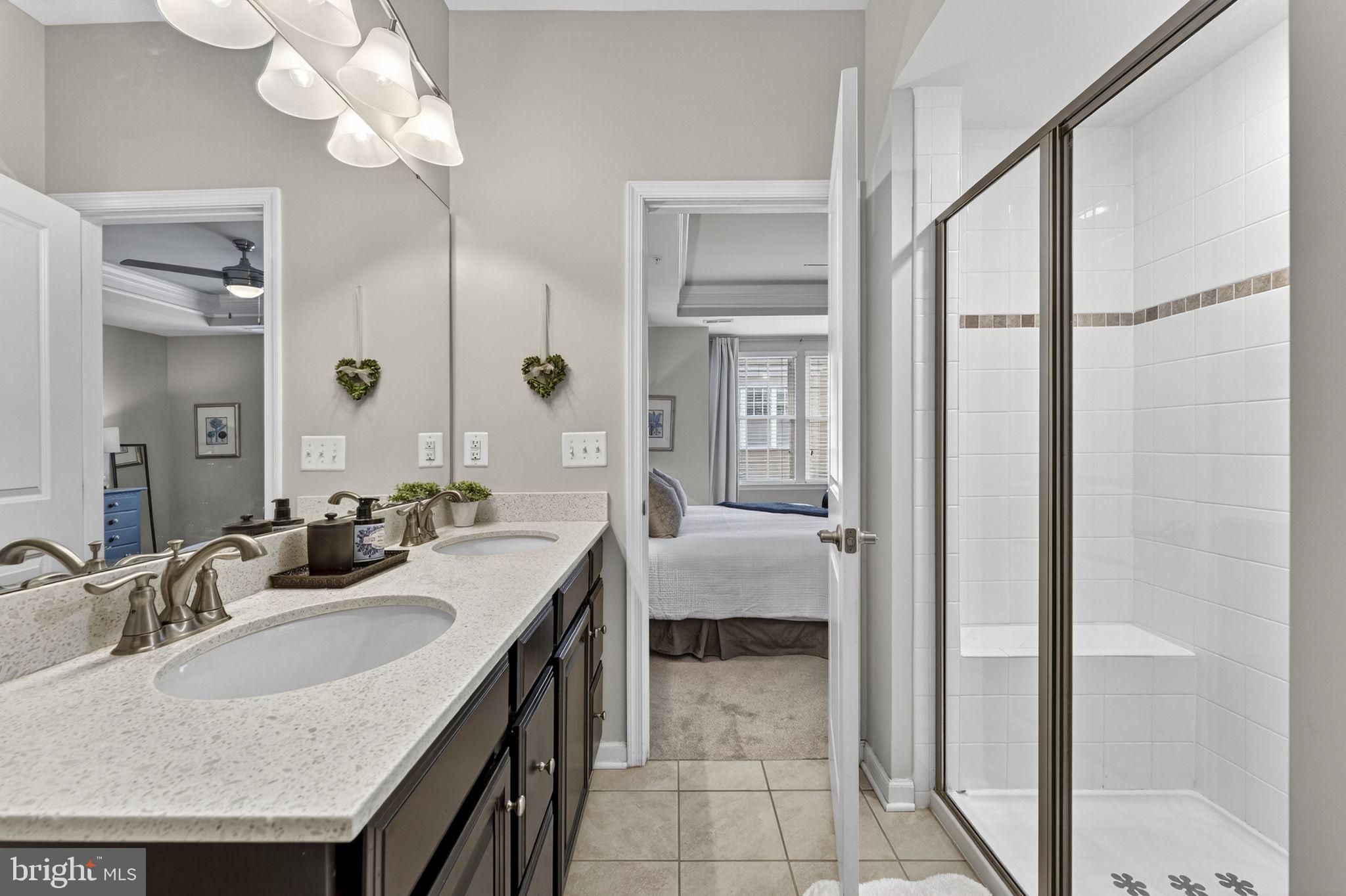 459 Haupt Square Southeast Leesburg, VA 20175 - Photo 37 of 80 a bathroom with a granite countertop sink a mirror and a shower