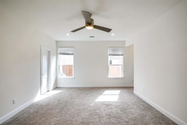 an empty room with a window and a ceiling fan