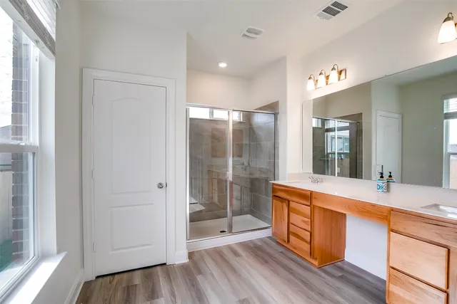 a large bathroom with a glass door shower and sink