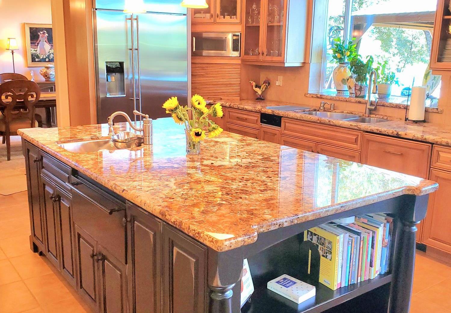 1440 Dog Bar Road Colfax, CA 95713 - Photo 16 of 93 Kitchen featuring light tile patterned floors, decorative pendant light fixtures, built in appliances, glass insert cabinets, appliance garage and an island with sink