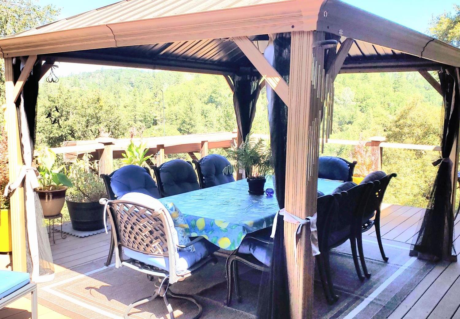 1440 Dog Bar Road Colfax, CA 95713 - Photo 40 of 93 Deck with a gazebo, outdoor dining space, and mountain views.