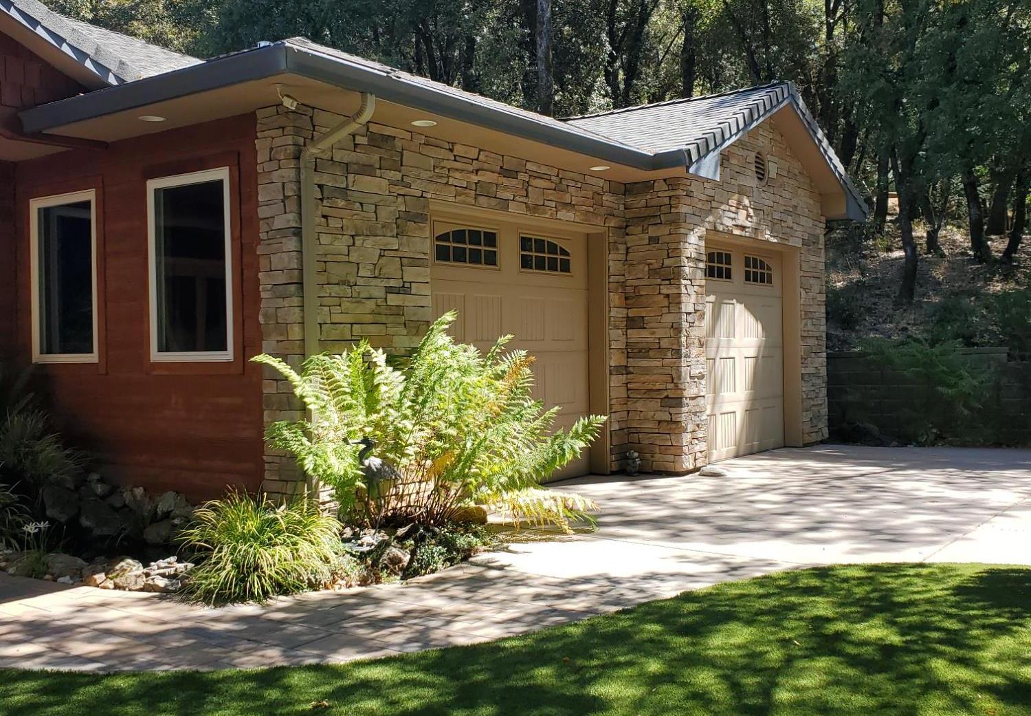 1440 Dog Bar Road Colfax, CA 95713 - Photo 64 of 93 View of side of home featuring HARDY plank and stone siding. Attached 2 car garage, driveway and low maintenance artificial grass. (Perhaps a future putting green?)