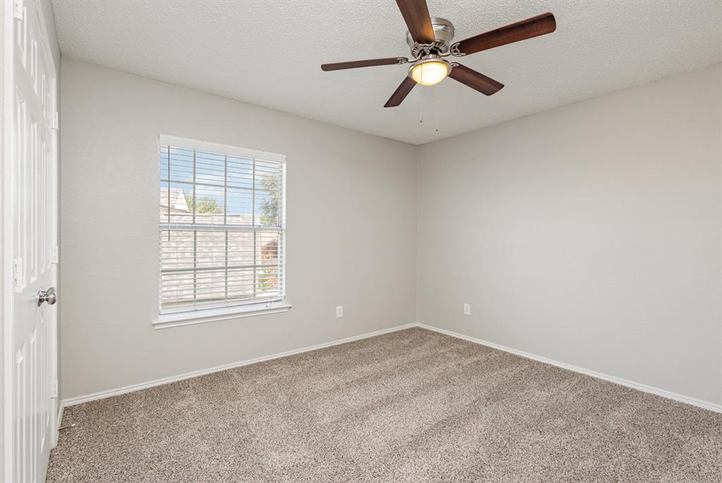 7100 Layla Road Arlington, TX 76016 - Photo 16 of 19 Carpeted empty room with a textured ceiling and ceiling fan